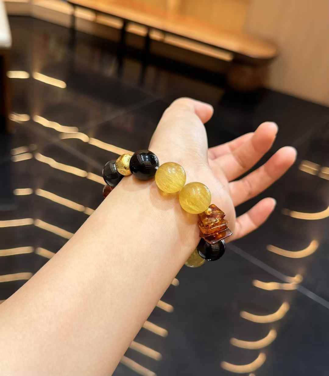 Chunky 16 mm mixed gemstone bracelet worn on the wrist with Yellow Fluorite and dark obsidian beads