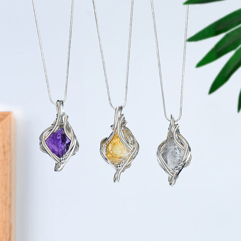 Amethyst freeform crystal pendant necklace with sculptural silver-tone wire wrapping and snake-style chain