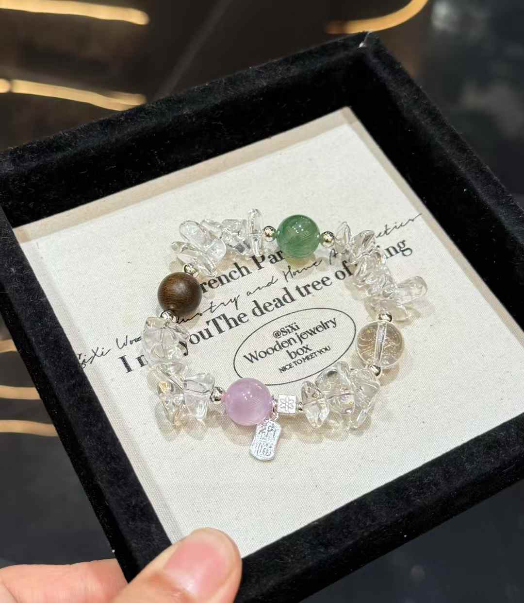 Full view of Clear Quartz chip bracelet with green gemstone, lavender Kunzite bead and Agarwood accent