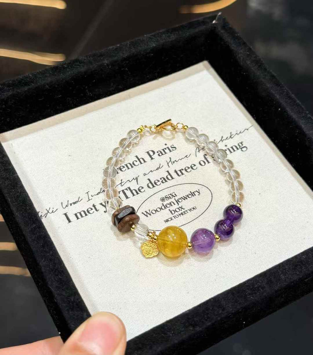 Close product view showing transparent Clear Quartz beads, Amethyst, Yellow Fluorite and natural Agarwood accents