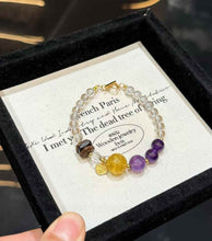 Close product view showing transparent Clear Quartz beads, Amethyst, Yellow Fluorite and natural Agarwood accents