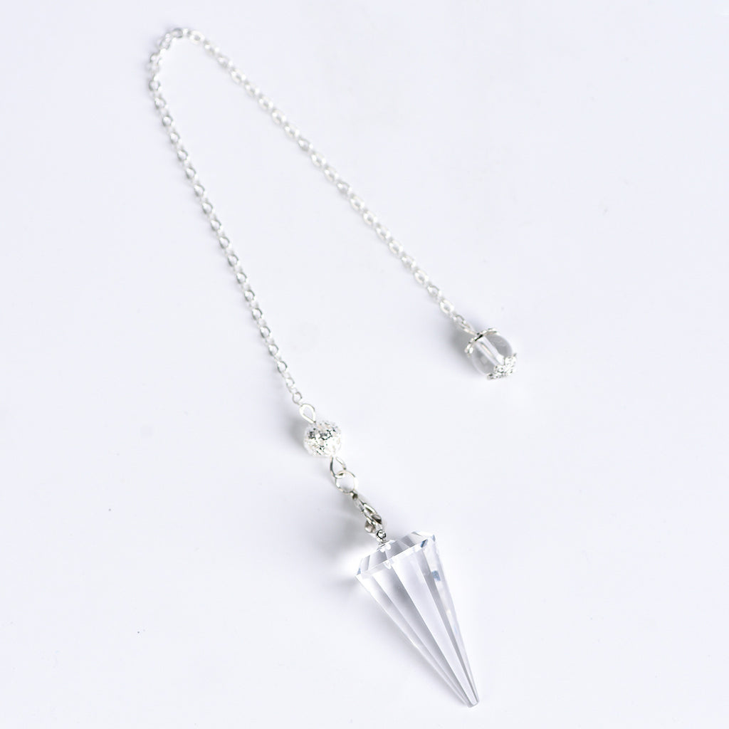 12-facet crystal pendulum displayed beside everyday objects to show its compact scale