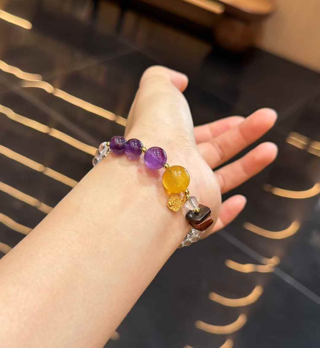 Double-strand crystal bracelet worn on the wrist with Amethyst, Yellow Fluorite and Agarwood focal details