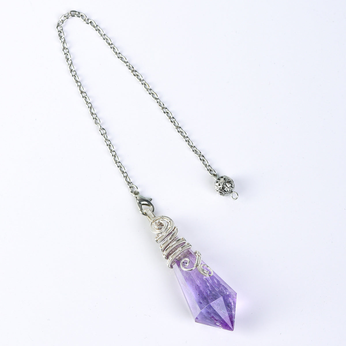 Full crystal pendulum and chain shown on a white surface to illustrate the overall scale and proportions