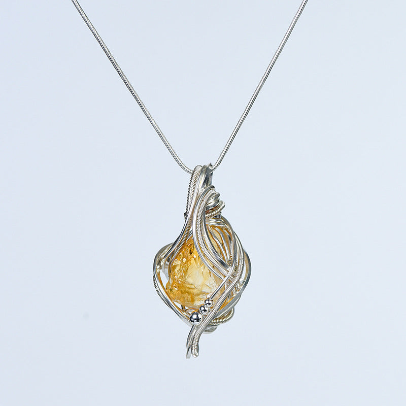 Freeform wire-wrapped crystal pendant necklace worn at the neckline to show its statement scale