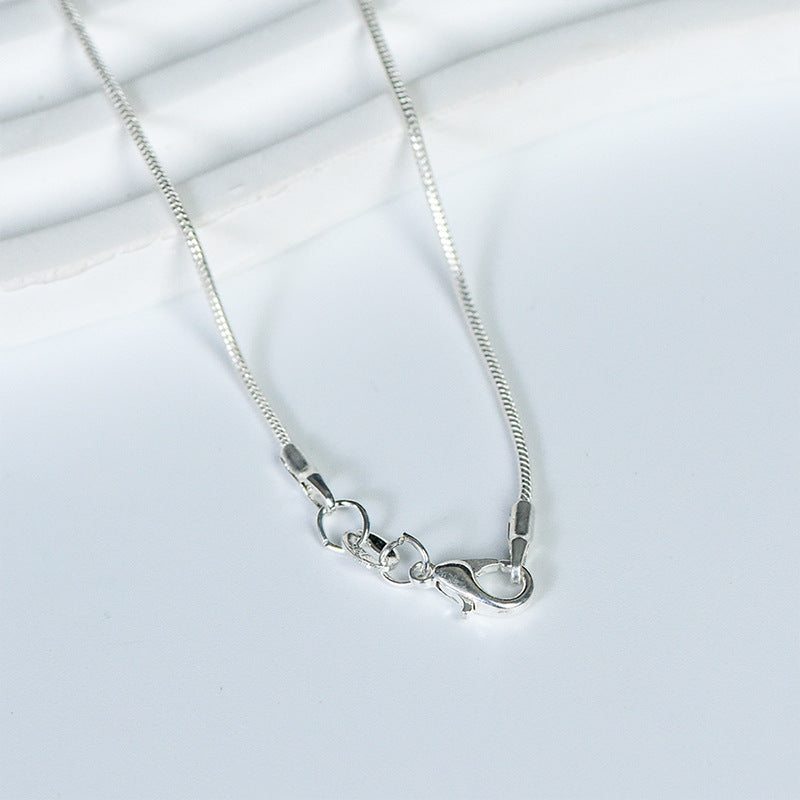 Close-up of a freeform crystal stone showing its natural texture inside a sculptural wire-wrapped setting