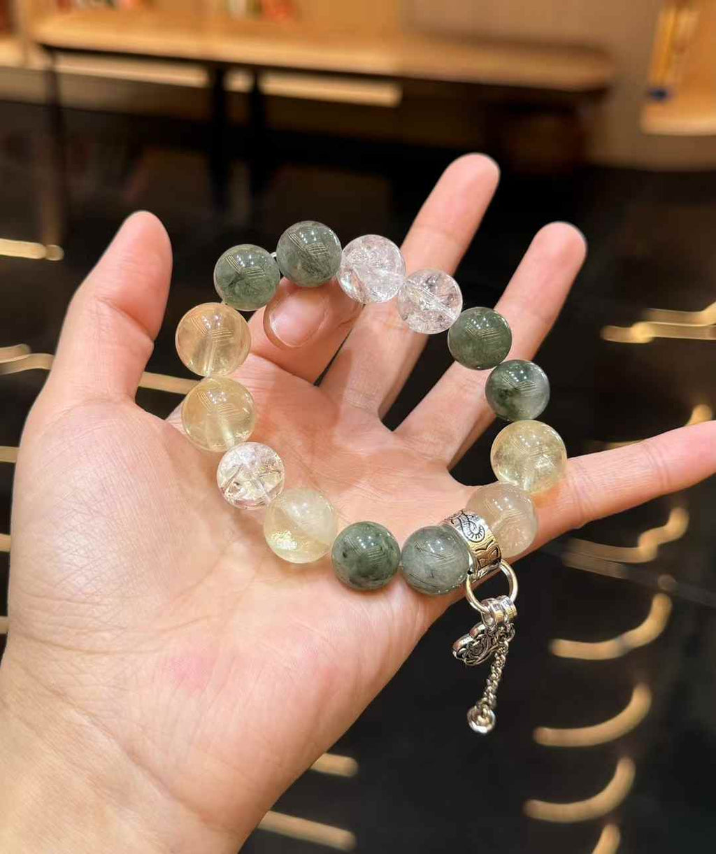 Green Rutilated Quartz and Lemon Quartz bracelet worn on the wrist showing the scale of the large polished beads
