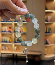 Hanging view of the Green Rutilated Quartz bracelet showing the full circular bead arrangement and dangling charm