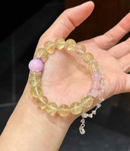 Detail view of the bracelet showing the dangling charm, silver-plated copper accents and pastel crystal arrangement