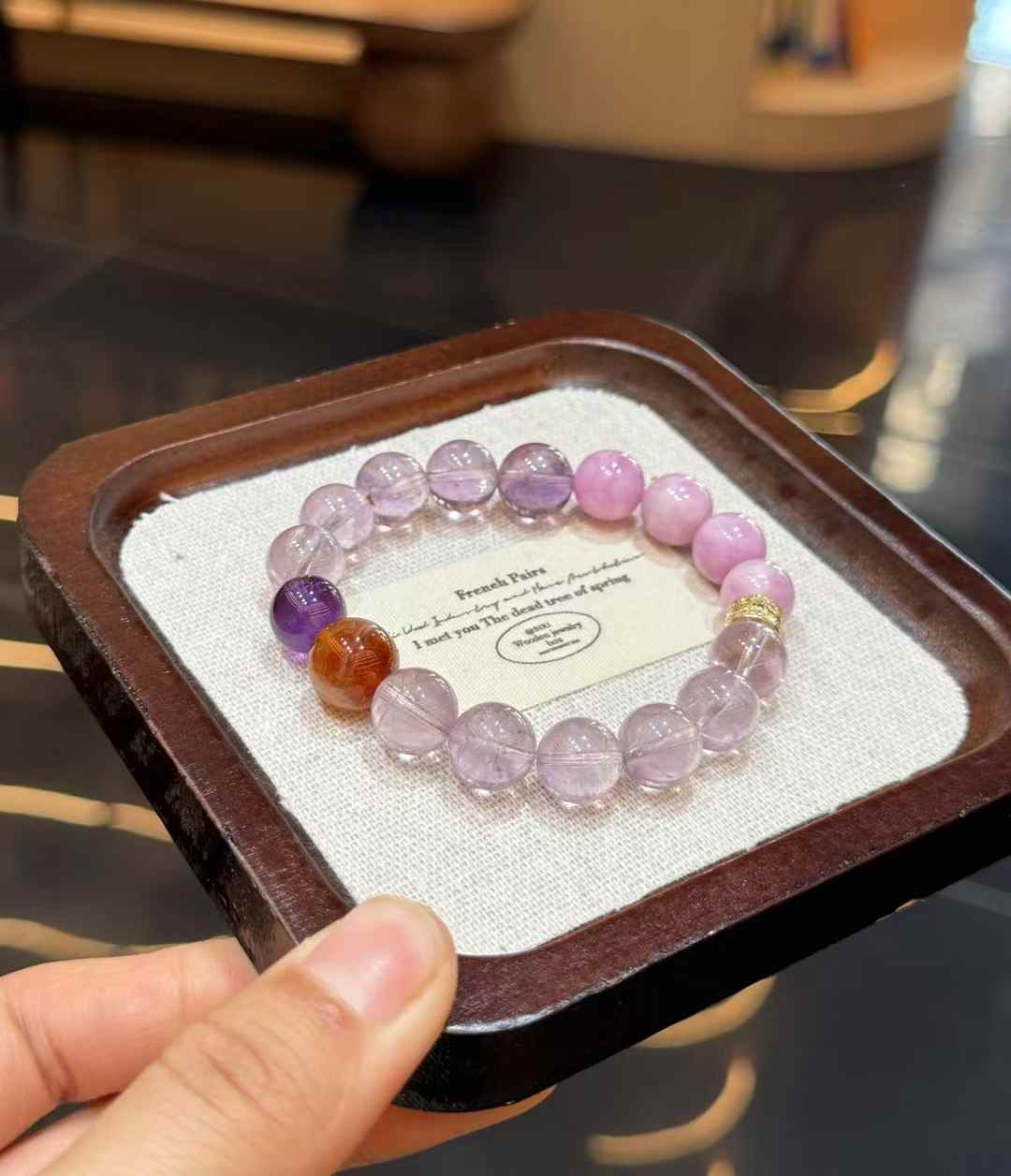 Flat lay image of the lilac-toned crystal bracelet on a neutral jewelry display tray