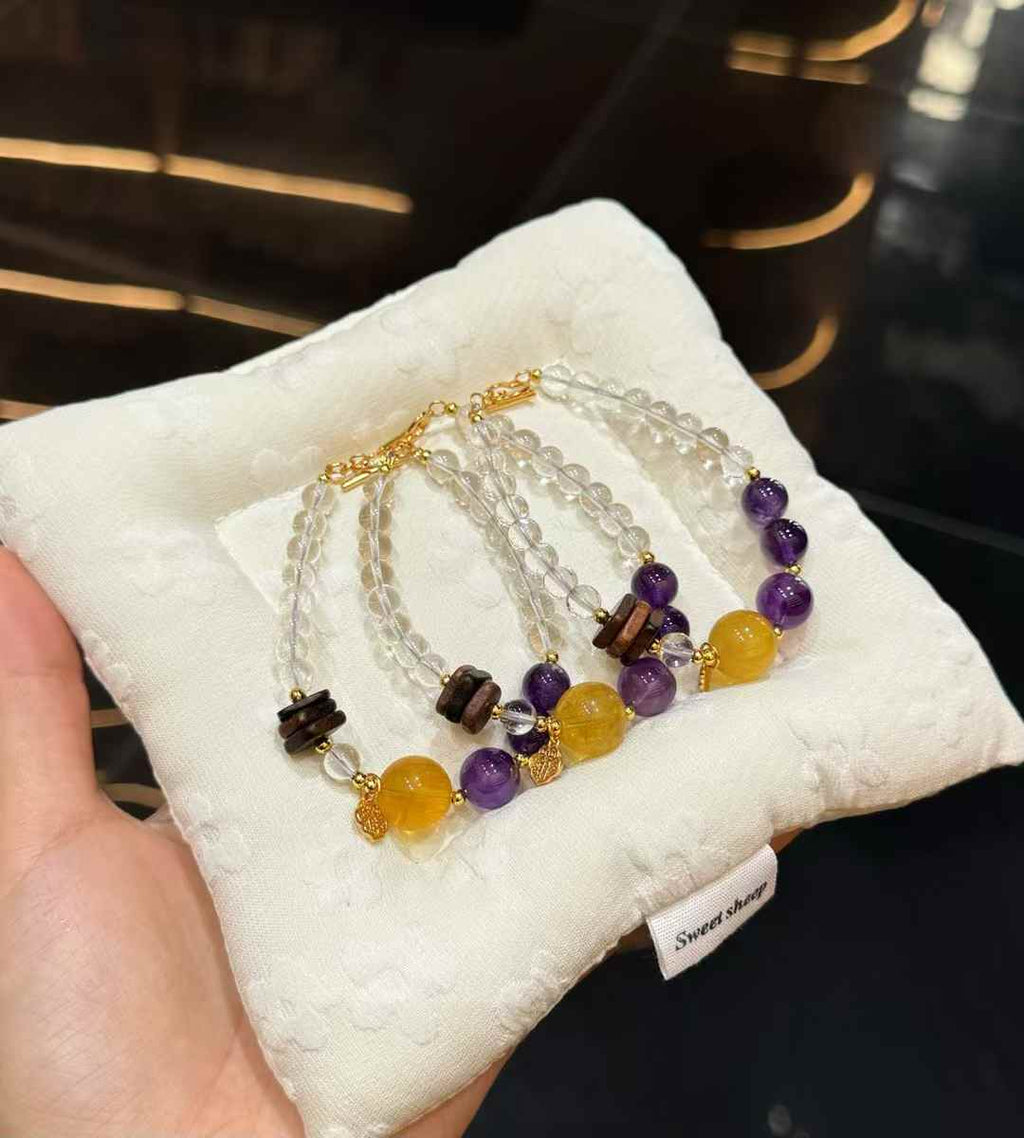 Multiple double-strand mixed crystal bracelets displayed together with clear, purple, golden and brown accents