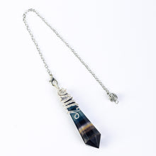Assorted faceted natural crystal pendulums displayed together as a coordinated crystal collection