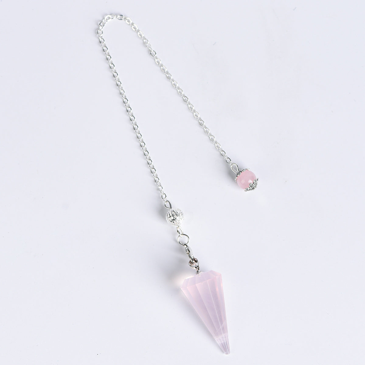 Natural crystal pendulum arranged in a clean jewelry and spiritual gift display