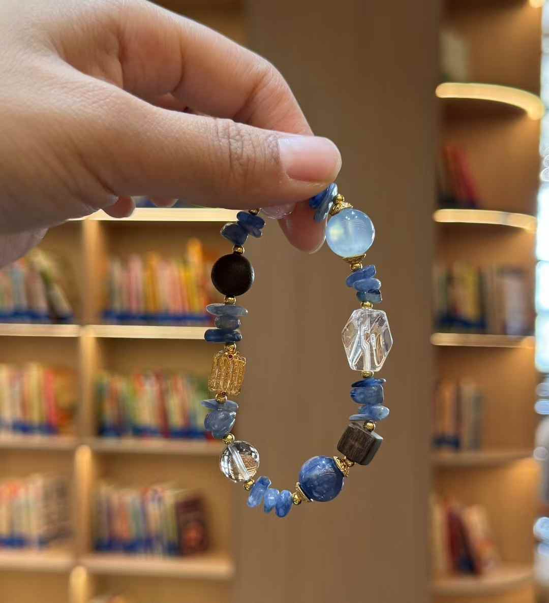 Ocean gradient bracelet held up to show the full circular shape and the transition from pale blue to deeper blue tones