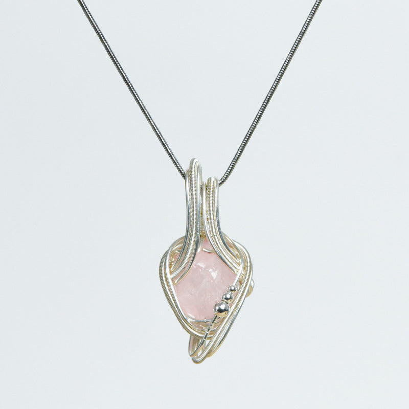 Freeform crystal pendant highlighting its organic stone shape and flowing sculptural wire-wrapped design