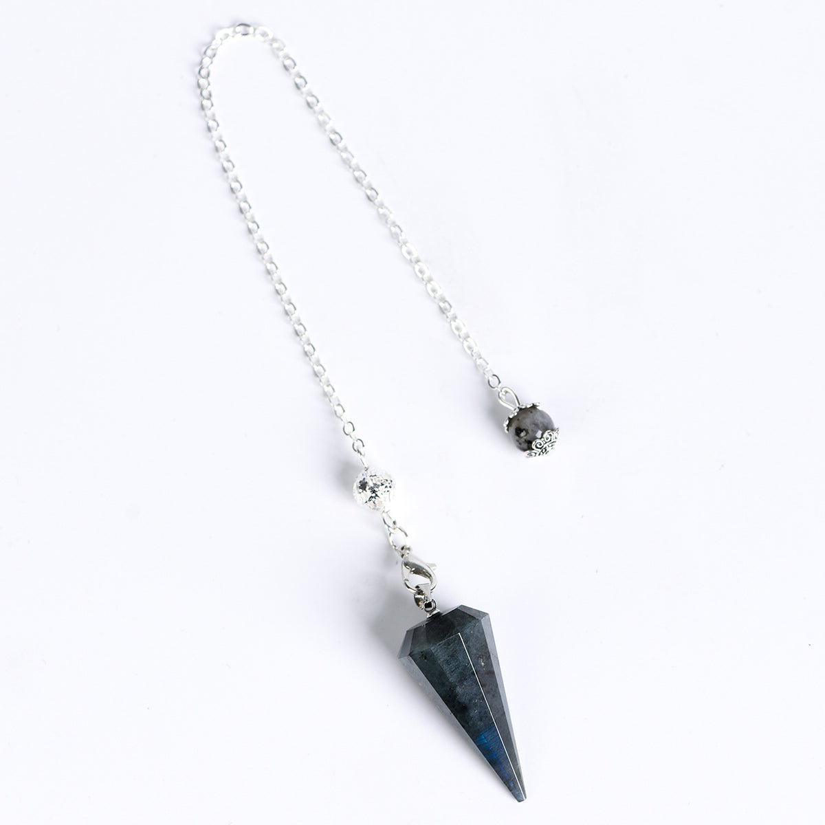 Pointed geometric crystal pendulum highlighting its symmetrical 12-facet cone design