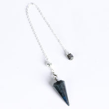 Pointed geometric crystal pendulum highlighting its symmetrical 12-facet cone design