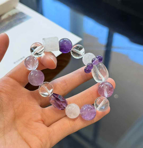 Full view of the purple and clear crystal bracelet showing round, faceted, cube and oval bead shapes