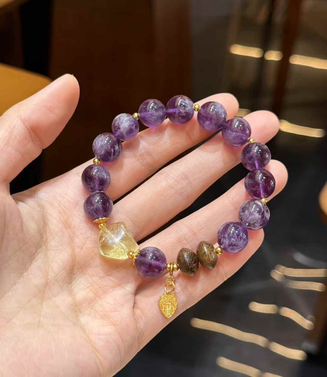 Hanging view of the Purple Rabbit Hair Quartz bracelet showing the full circular design and contrasting Citrine centerpiece