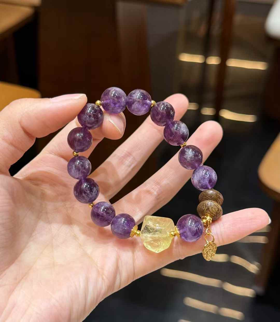 Full view of the purple crystal bracelet showing round Purple Rabbit Hair Quartz beads, freeform Citrine and Agarwood accents