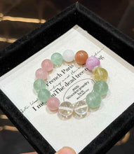 Close-up of a colorful gemstone bracelet showing round Clear Quartz, Green Fluorite, Kunzite and warm-toned crystal beads