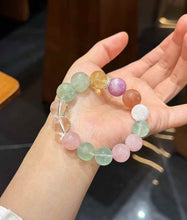Rainbow multi-gemstone bead bracelet arranged on soft white fabric in a casual lifestyle setting