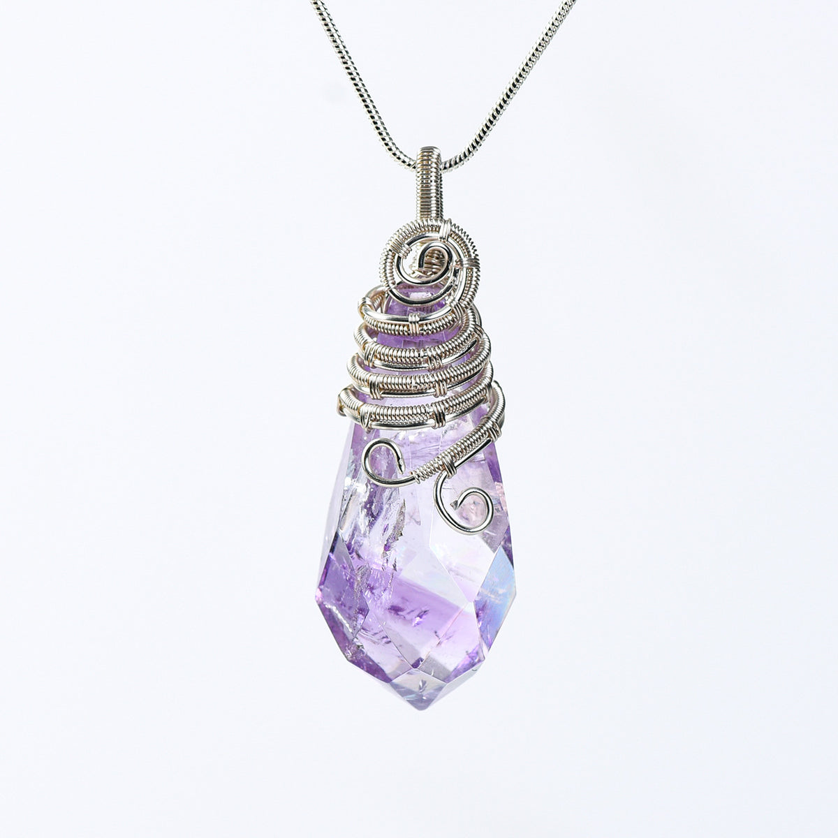 Faceted crystal pendant highlighting layered spiral wirework and organic handmade detailing