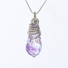 Faceted crystal pendant highlighting layered spiral wirework and organic handmade detailing