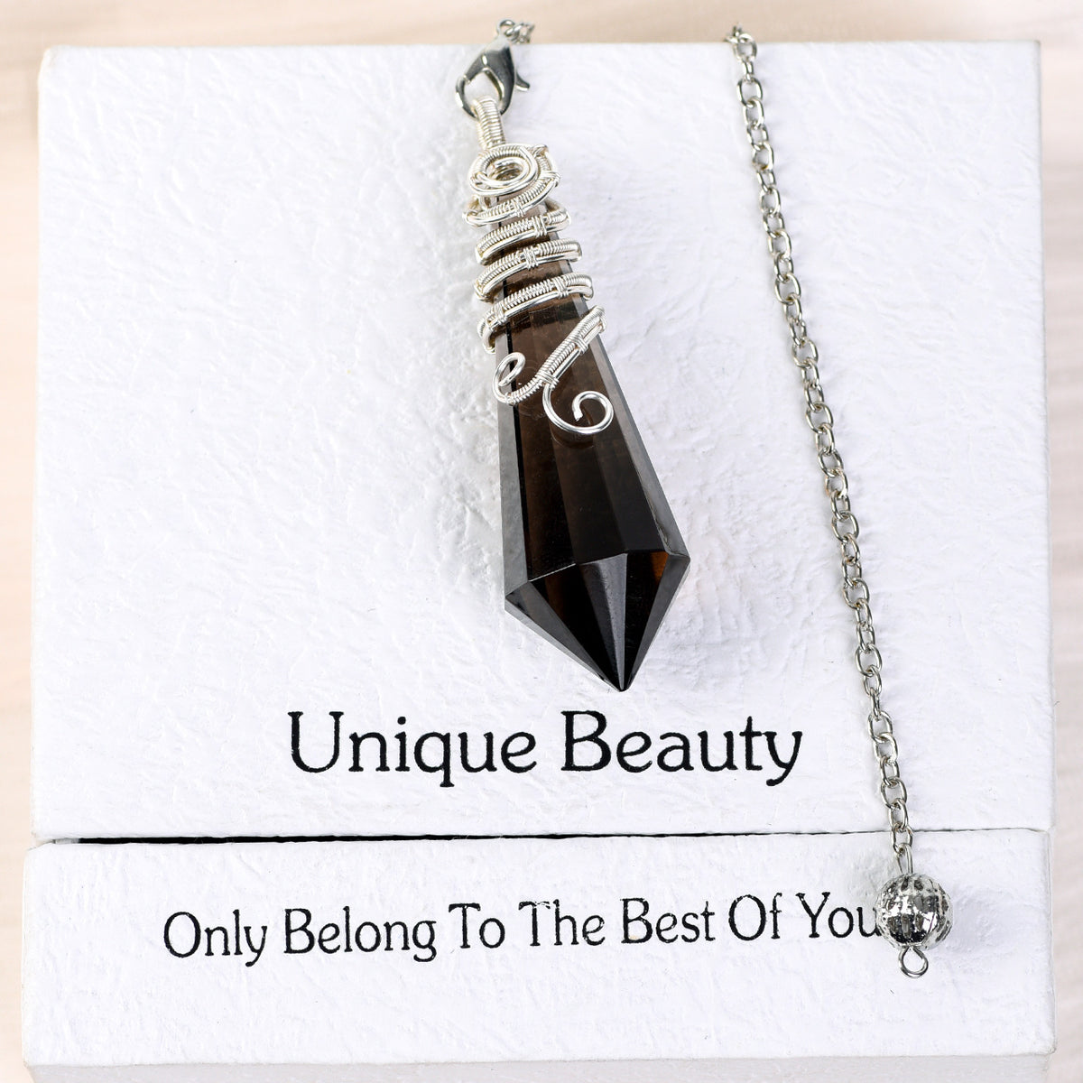 Close-up of decorative silver-tone wire wrapping around the upper section of a faceted crystal pendulum