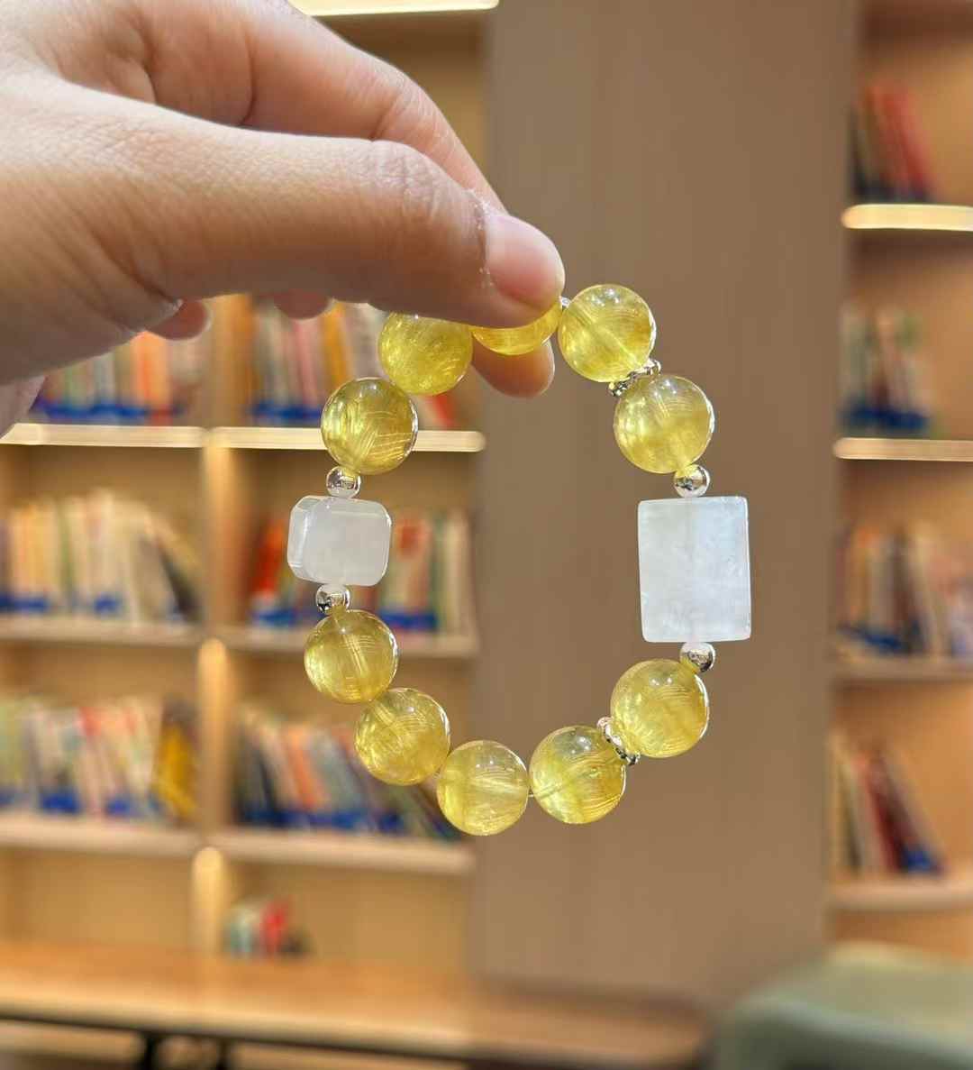 Full view of the Yellow Fluorite bracelet with White Phantom geometric accents held by hand