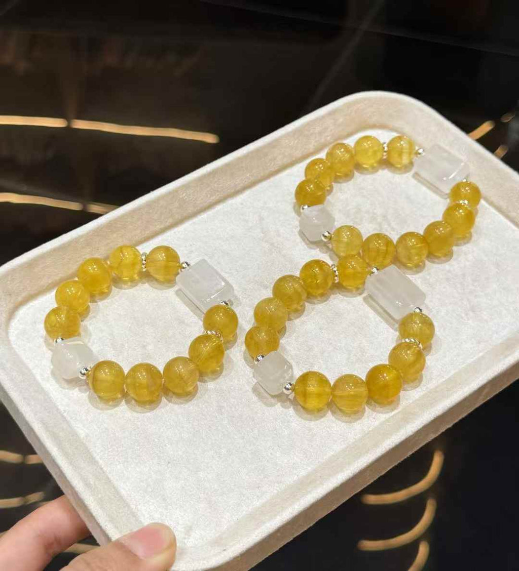 Veridia Yellow Fluorite and White Phantom bead bracelets displayed on a soft tray
