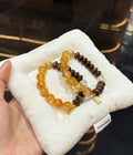 Veridia Yellow Hematoid Quartz and Agarwood bracelet displayed on a soft white jewelry cushion with Clear Quartz and gold-tone accents