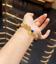 Yellow Tower Quartz mixed gemstone bracelet worn on the wrist with Lapis Lazuli and copper charm details