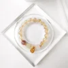 Antique Inspired Polished Gold Tone Drop Charm with Traditional Character Embossing
